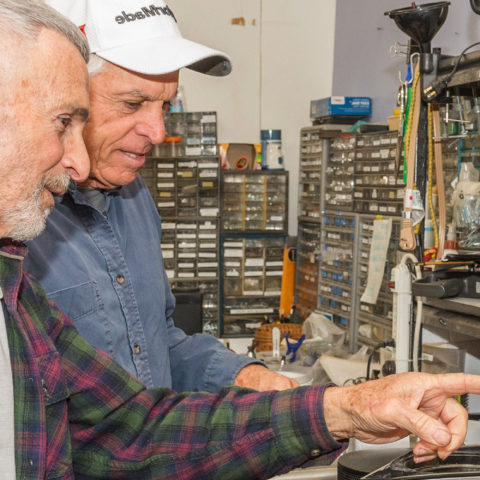 2 volunteers prepare electronics for re-sale