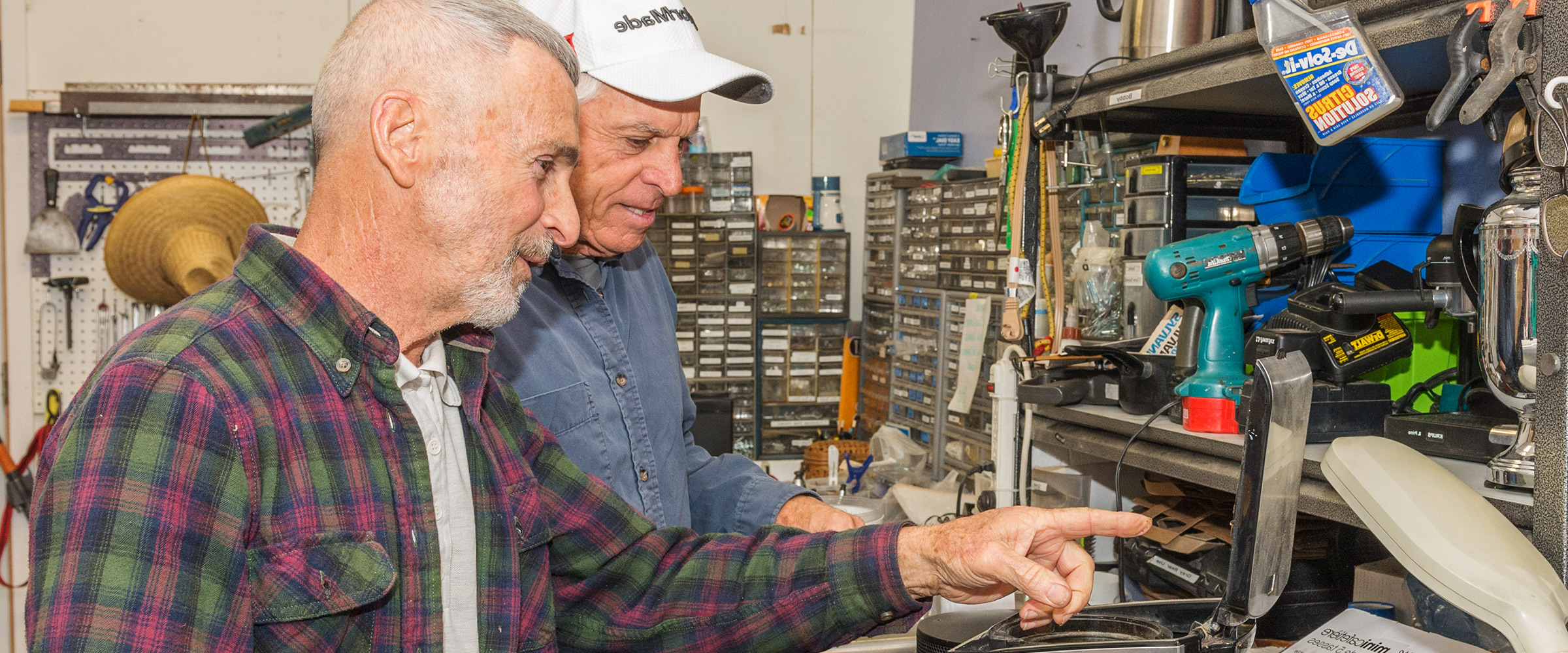 2 volunteers prepare electronics for re-sale
