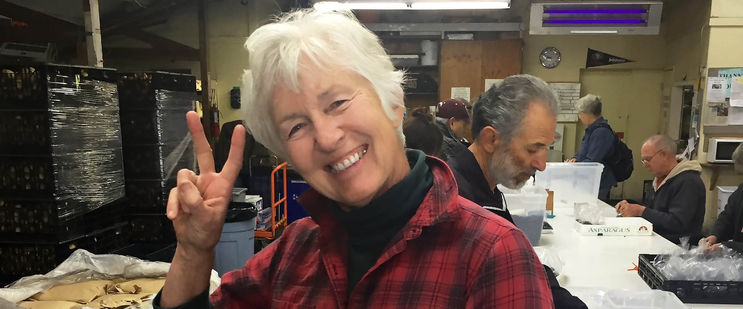 Smiling volunteer makes peace sign