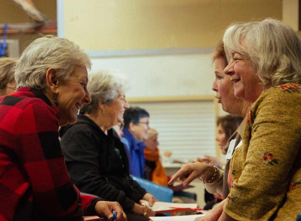 2 senior women in conversation at a Grey Bears event
